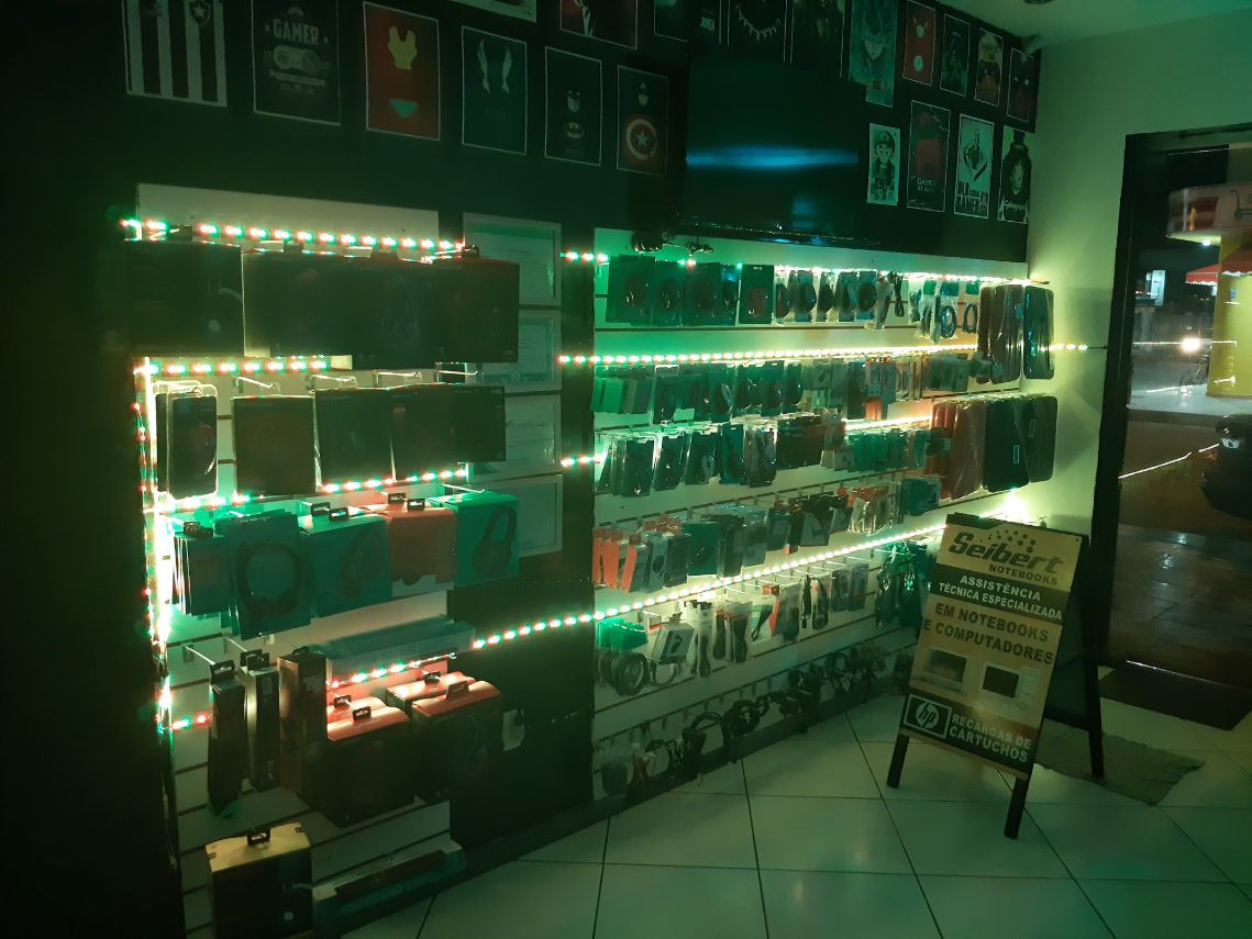 Loja iluminada à noite com fones, cabos e acessórios